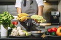 Close up of female hands holding fresh celery and bananas in the kitchen. Proper nutrition and health concept Royalty Free Stock Photo