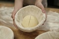 Close up of female hands holding fresh dough rising in bowl at bakery kitchen Royalty Free Stock Photo