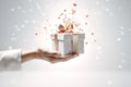 Close up of female hands holding gift box with ribbons and confetti Royalty Free Stock Photo