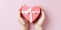 Close up on female hands holding a gift in a pink heart presents for valentine day Royalty Free Stock Photo