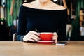 Close up female hands holding red tea mug in cafe Royalty Free Stock Photo