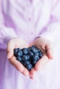 Close up of female hands holding tasty ripe blueberries
