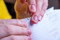 Close-up of female hands hooking a paperclip to sheets of paper, work at home, distance learning Royalty Free Stock Photo