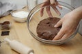 Close up of female hands kneading raw chocolate dough at home for cooking cookies Royalty Free Stock Photo