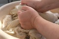 Close-up female hands of middle-aged woman wash at home in basin, pre-soak dirty sheets for washing, home chores concept, routine