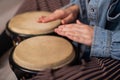 Close-up of female hands on mini bongo drums. The girl plays a traditional ethnic percussion instrument Royalty Free Stock Photo