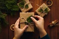 Female hands packing Christmas gifts on table, top view