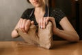 Close-up of the female hands of a potter, begins to make a product from clay, takes a large piece of material and