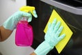 Close up of female hands with protective gloves cleaning oven door. Girl polishing kitchen. People, housework, cleaning concept Royalty Free Stock Photo