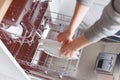 Close-up of female hands putting dishes to the dishwasher Royalty Free Stock Photo