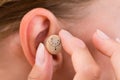 Female Hands Putting Hearing Aid In Ear Royalty Free Stock Photo