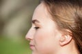 Close-up Of Female Hands Putting Hearing Aid In Ear. Modern digital in the ear hearing aid for deafness and the hard of hearing Royalty Free Stock Photo