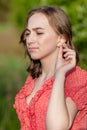 Close-up Of Female Hands Putting Hearing Aid In Ear. Modern digital in the ear hearing aid for deafness and the hard of hearing Royalty Free Stock Photo