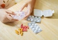 Close-up of female hands putting pills into plastic containers, Hands with pills and pillboxes Royalty Free Stock Photo