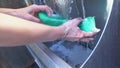 close-up of female hands rinsing a large sponge in an industrial sink