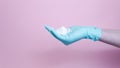 Close-up of female hands with rubber glove pumping cleansing foam on pink background. Concept of face cleanser, cosmetics Royalty Free Stock Photo