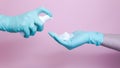 Close-up of female hands with rubber glove pumping cleansing foam on pink background. Concept of face cleanser, cosmetics Royalty Free Stock Photo