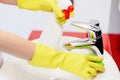 Close up of female hands with rubber gloves cleaning tap. Royalty Free Stock Photo