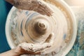 Female hands sculpting clay on a Potter`s wheel. Concept of hobby and cretivity at home and in the Studio workshop