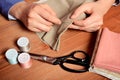 Close-up female hands sewing fabric on old wooden table