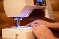 Close-up female hands sewing fabric on sewing machine Royalty Free Stock Photo