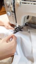 Close up female hands stitch white fabric on modern sewing machine Royalty Free Stock Photo