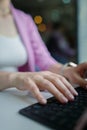 Close-up on female hands typing on laptop keyboard, copy space, vertical Royalty Free Stock Photo