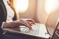 Close-up of female hands using laptop. Woman working while going on business trip by plane Royalty Free Stock Photo