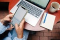 Close up of female hands using smartphone and laptop in cafe Royalty Free Stock Photo