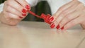 Close up of female hands. woman paints her nails with red nail polish