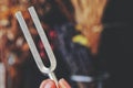 Close up of female holding a tuning fork in her hand in between fingers Royalty Free Stock Photo
