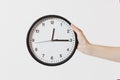 Close up female holds in hand round black and white clock isolated on white background. Time concept. Time is running