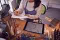 Close Up Of Female Jeweller Looking At Ring Design On Digital Tablet In Studio