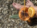 A glass of orange juice and a piece of lemon on the beach Royalty Free Stock Photo