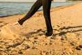 Close up female legs in black pants on beach Royalty Free Stock Photo