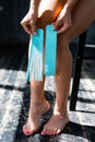 Close-up of female legs. The girl holds a kinesio tape in her hands to fix the calf muscles