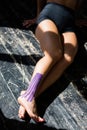 Close-up of female legs. A girl sits on the floor with a kinesiotherapy tape on the lower leg Royalty Free Stock Photo