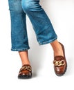 Female legs in jeans and brown casual leather shoes Royalty Free Stock Photo