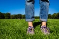 Close-up of female legs in jeans and sport shoes on the grass in Central Park Royalty Free Stock Photo