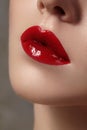 Close-up of female lips with bright makeup. Macro of woman's face. Fashion lip make-up with red gloss