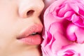 Close-up of female lips with pink flower. Closeup sexy female lip with red color lipstick. Women's lips and red flower Royalty Free Stock Photo