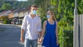 CLOSE UP: Girl looks into boyfriends eyes as they walk down street wearing masks