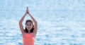 Close up female master yoga doing tress pose at beach and blue s