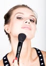 Close-up Female model applying makeup on her face. Beautiful young woman applying foundation on her face with a make up Royalty Free Stock Photo