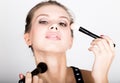 Close-up Female model applying makeup on her face. Beautiful young woman applying foundation on her face with a make up Royalty Free Stock Photo