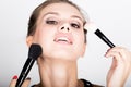 Close-up Female model applying makeup on her face. Beautiful young woman applying foundation on her face with a make up Royalty Free Stock Photo