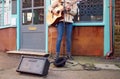 Close Up Of Female Musician Busking Playing Acoustic Guitar Outdoors In Street