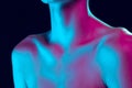 Close up female neck, collarbones and shoulders in pink neon light over dark background. Natural beauty, fitness, diet Royalty Free Stock Photo