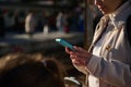 Close-up woman checking her online ticket on mobile app on her smartphone, waiting for the train in the railway station Royalty Free Stock Photo