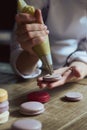 Close up of female pastry chef's hand cooking delicious macaroon